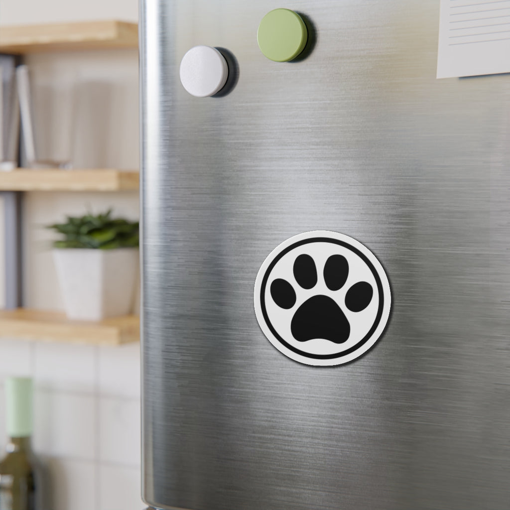 Black-and-white cat paw print die-cut magnet with a circular border, shown on a refrigerator door – Kate Spain design