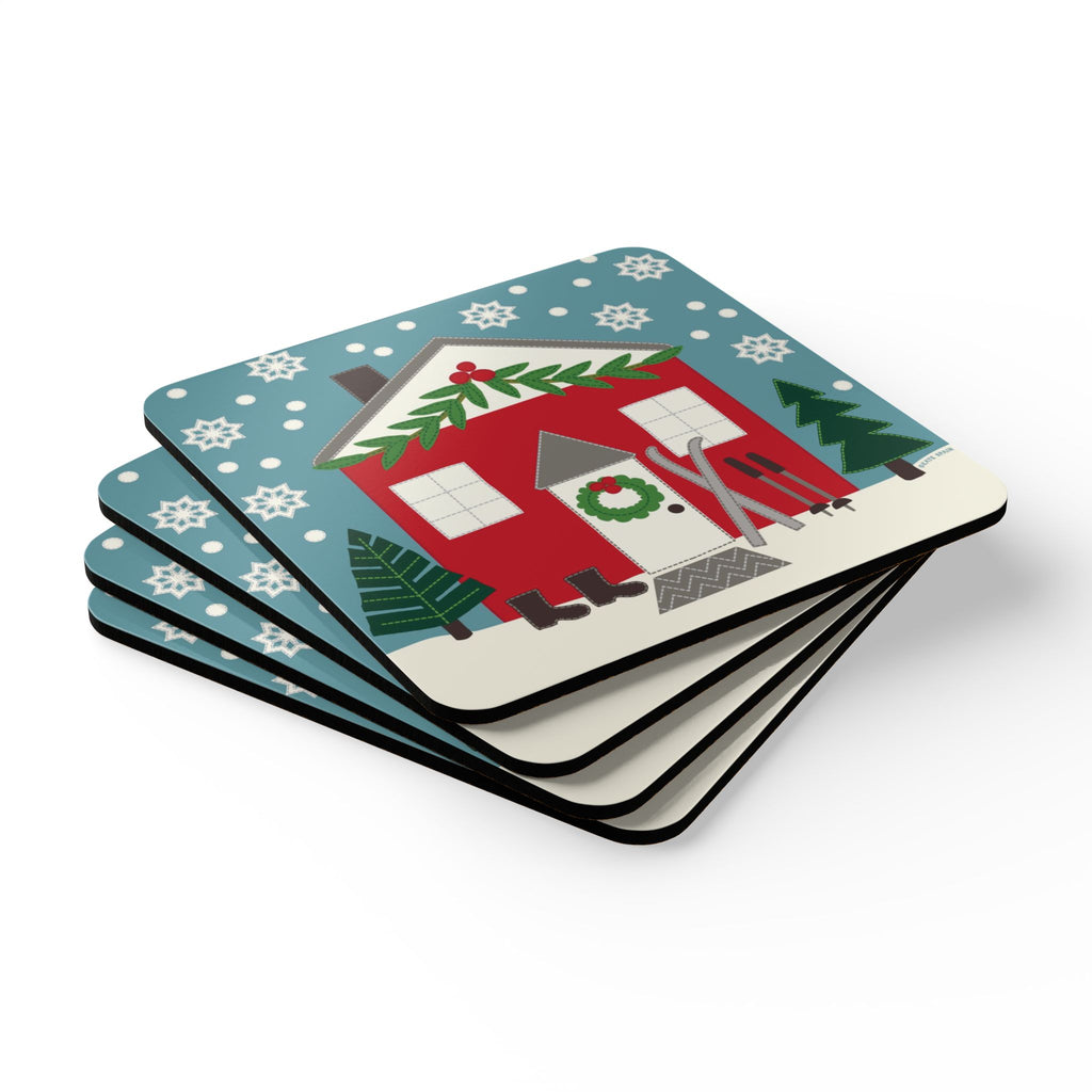 Ski Chalet cork-backed coaster set of four, red holiday cottage with skis among snowy evergreens, stacked set, angled view – Kate Spain design