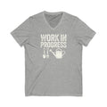 Garden Work in Progress distressed lettering with a shovel, pitchfork and watering can on a V-neck t-shirt in athletic heather grey, front view – Kate Spain design
