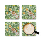 Partridge cork-backed coaster set of four, folk-art partridge among golden pears and patterned leaves on sage green, four coasters with a latte mug – Kate Spain design