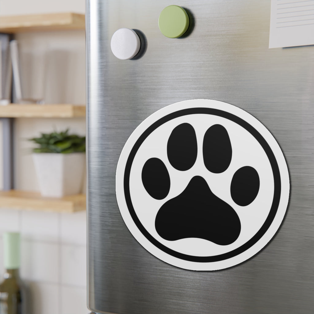 Black-and-white dog paw print die-cut magnet with a circular border, shown on a refrigerator door – Kate Spain design