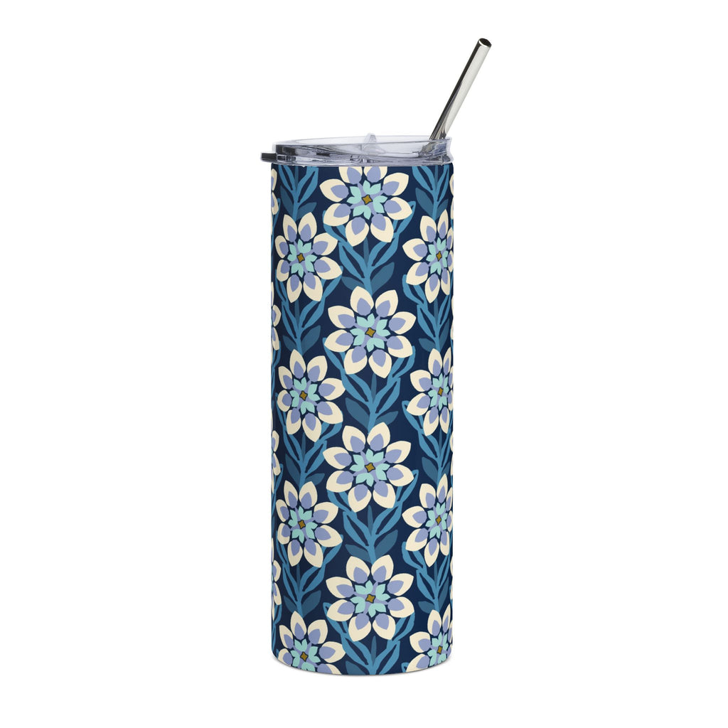 A tall, skinny tumbler with a navy blue background and a repeating floral pattern in light blue, white, and soft yellow. It has a clear lid with a black metal straw, shown on a plain white background.