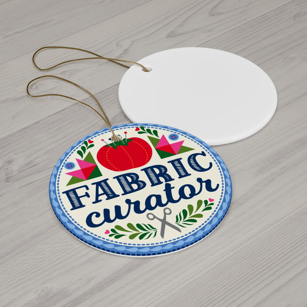 Fabric Curator round porcelain Christmas ornament, front and blank back on a table – Kate Spain design for Pat Sloan