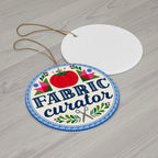 Fabric Curator round porcelain Christmas ornament, front and blank back on a table – Kate Spain design for Pat Sloan
