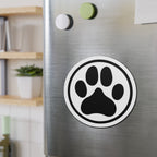 Black-and-white dog paw print die-cut magnet with a circular border, shown on a refrigerator door – Kate Spain design