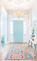Talavera hand-tufted wool rug with a coral, blush, soft aqua and grey tile medallion pattern, in a bright entry hall – Kate Spain design