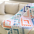 Nomad quilt draped on a couch