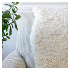 nothing to hide hand-knotted shag throw rug in undyed natural white New Zealand wool, draped over a sofa – Kate Spain design