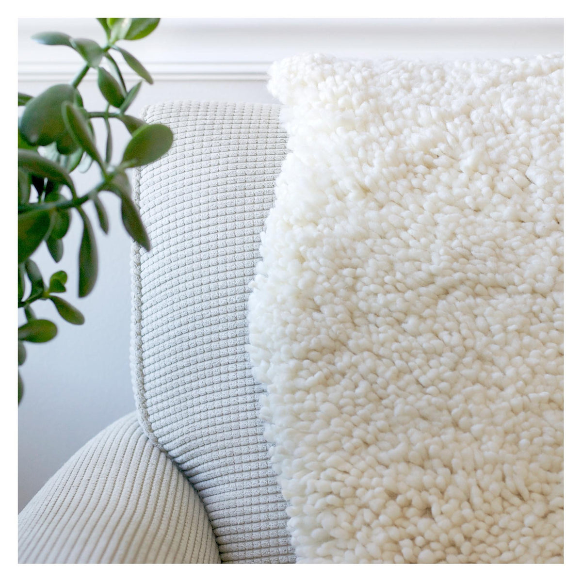 nothing to hide hand-knotted shag throw rug in undyed natural white New Zealand wool, draped over a sofa – Kate Spain design
