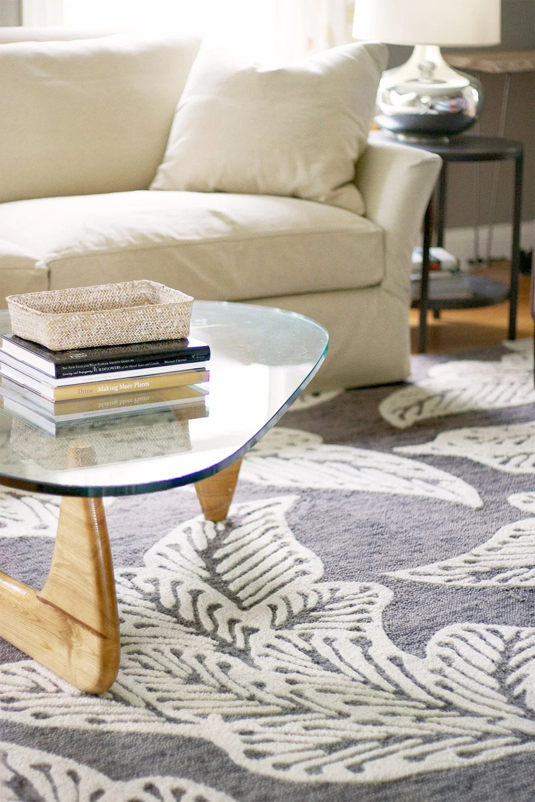 eye heart hand Taupe Leaf hand-tufted wool rug with oversized cream leaves on taupe, under a glass coffee table in a living room – Kate Spain design