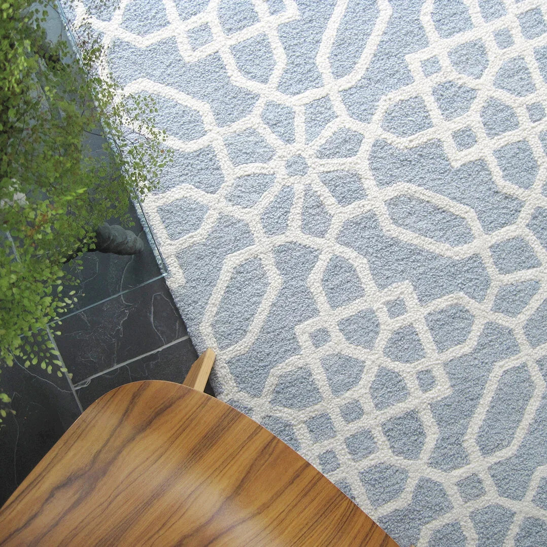 eye heart hand Atrium hand-tufted wool rug with a blue-grey and cream geometric lattice, corner beside a wooden chair and fern – Kate Spain design