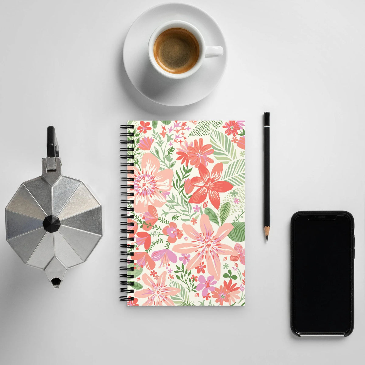 Bonaire Spiral Notebook in Coral on a desk with an espresso cup, pencil and phone – Kate Spain design