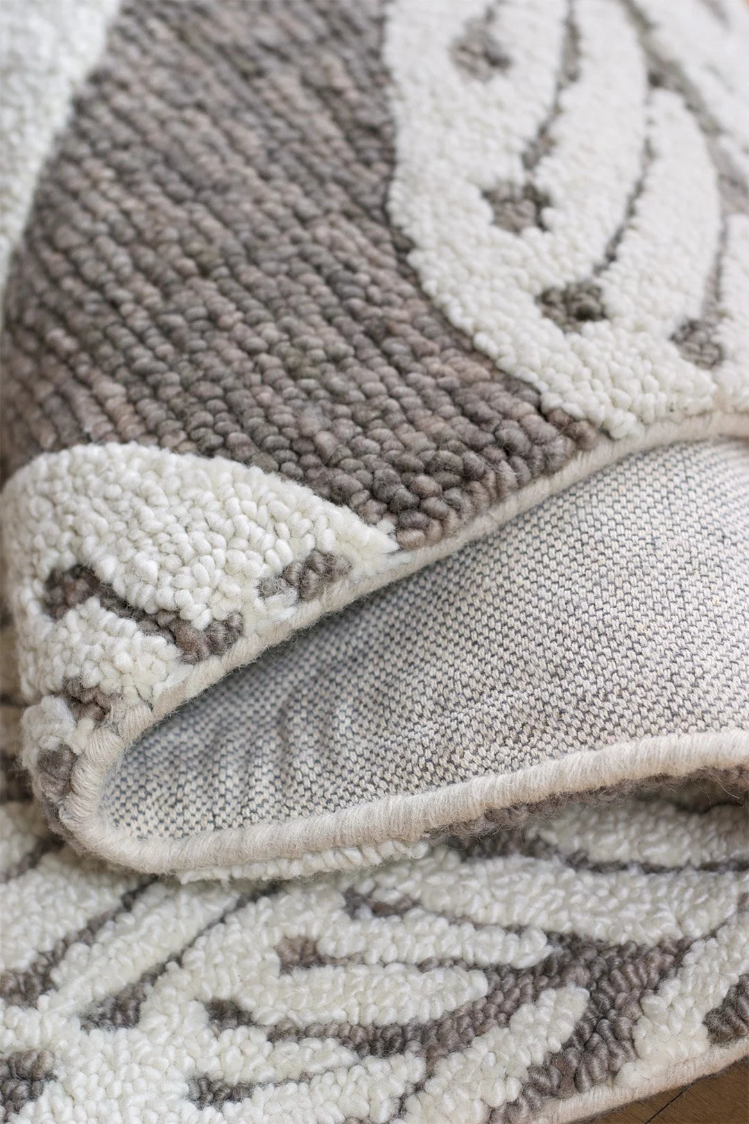 eye heart hand Taupe Leaf hand-tufted wool rug with oversized cream leaves on taupe, corner turned up to show the back and looped pile – Kate Spain design