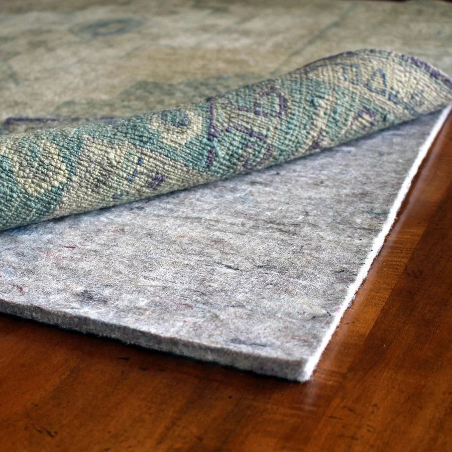 Premium rug pad of recycled felt with natural rubber grid backing, felt pad beneath a rug on a hardwood floor