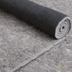 Premium rug pad of recycled felt with natural rubber grid backing, partly rolled to show the rubber backing