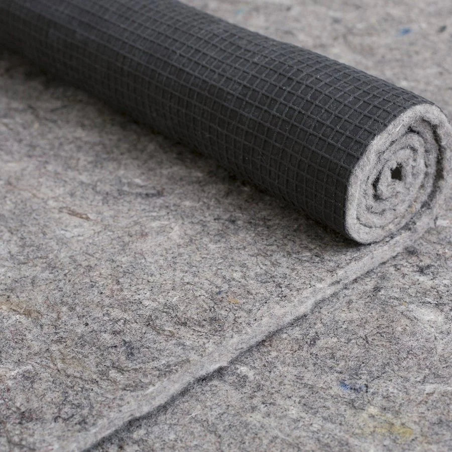 Premium rug pad of recycled felt with natural rubber grid backing, partly rolled to show the rubber backing