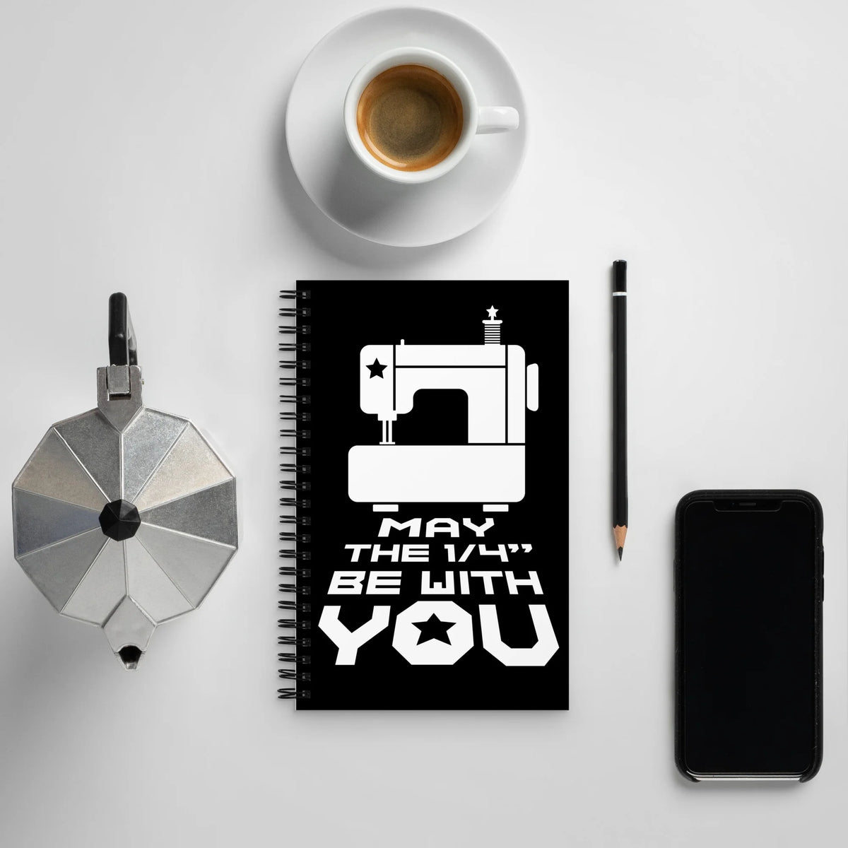 May the ¼" Be With You spiral notebook with a sewing machine, on a desk with coffee – Kate Spain design for Pat Sloan