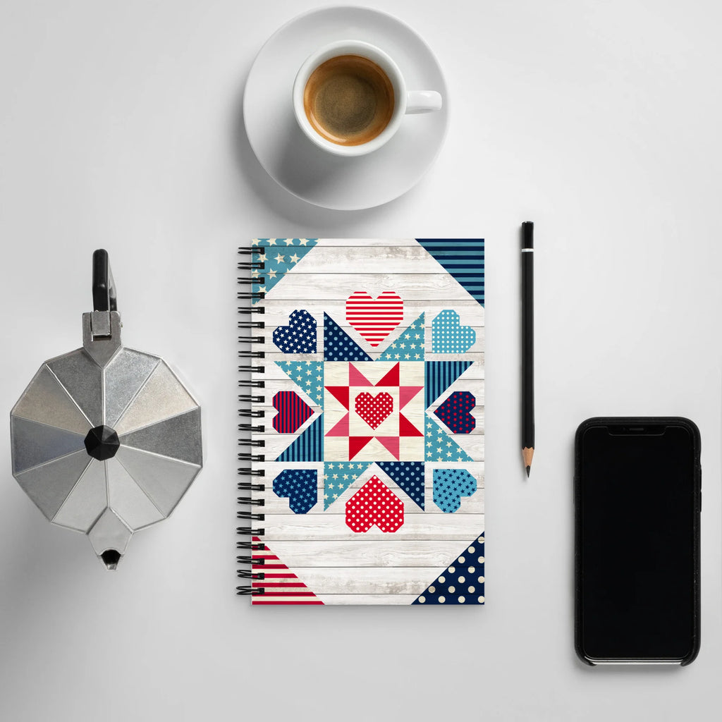 Liberty Love spiral notebook with star quilt blocks and hearts, on a desk with coffee – Kate Spain design for Pat Sloan