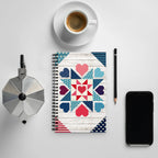 Liberty Love spiral notebook with star quilt blocks and hearts, on a desk with coffee – Kate Spain design for Pat Sloan