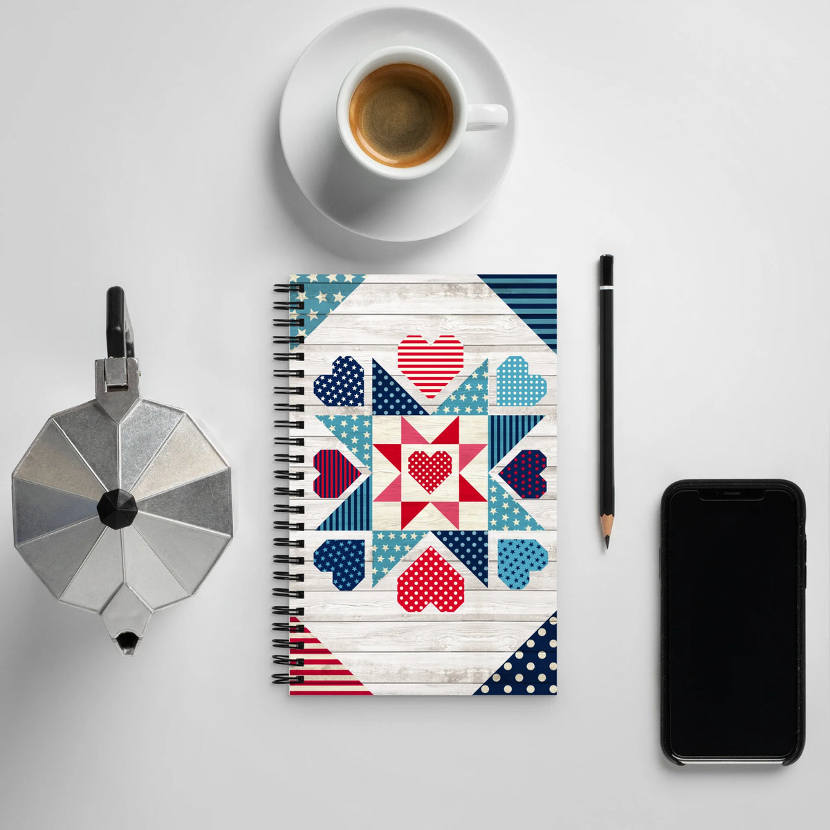 Liberty Love spiral notebook with star quilt blocks and hearts, on a desk with coffee – Kate Spain design for Pat Sloan