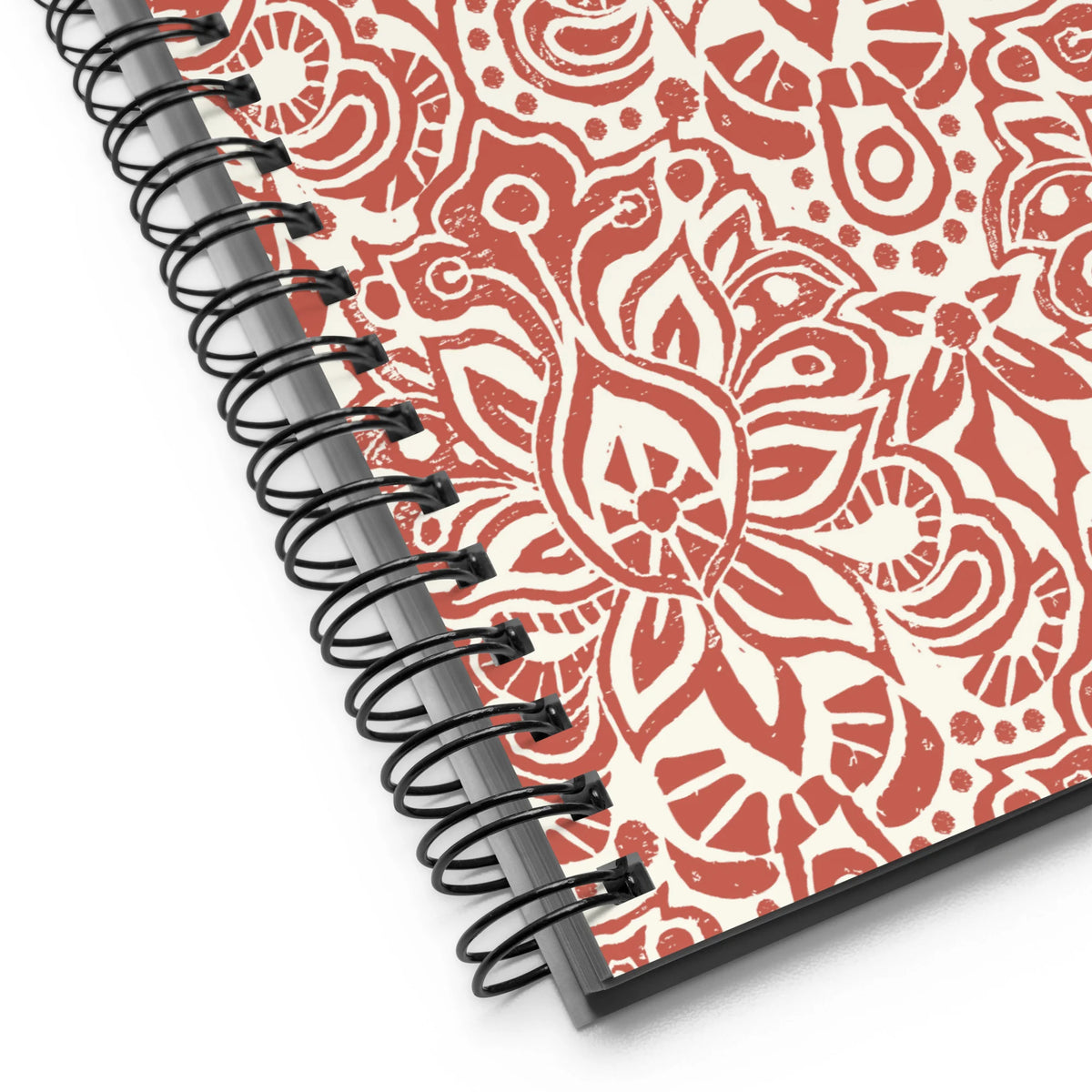 Earth spiral notebook in Clay, clay-red block-print medallions on cream, close-up of the spiral binding – Kate Spain design