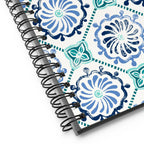 Horizon Tile spiral notebook with blue and teal pinwheel tile medallions on cream, close-up of the spiral binding – Kate Spain design