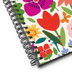 Happy Blooms spiral notebook with bright flat-color tulips, daisies, a butterfly and a ladybug on cream, close-up of the spiral binding – Kate Spain design