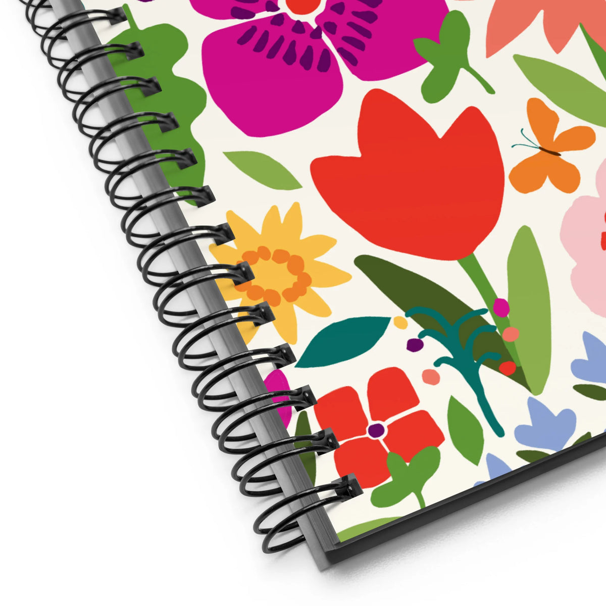 Happy Blooms spiral notebook with bright flat-color tulips, daisies, a butterfly and a ladybug on cream, close-up of the spiral binding – Kate Spain design