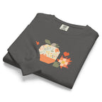 Falling for Fall patchwork pumpkin with quilt-block stars and hearts on a garment-dyed crewneck sweatshirt in pepper grey, folded, angled view – Kate Spain design for Pat Sloan