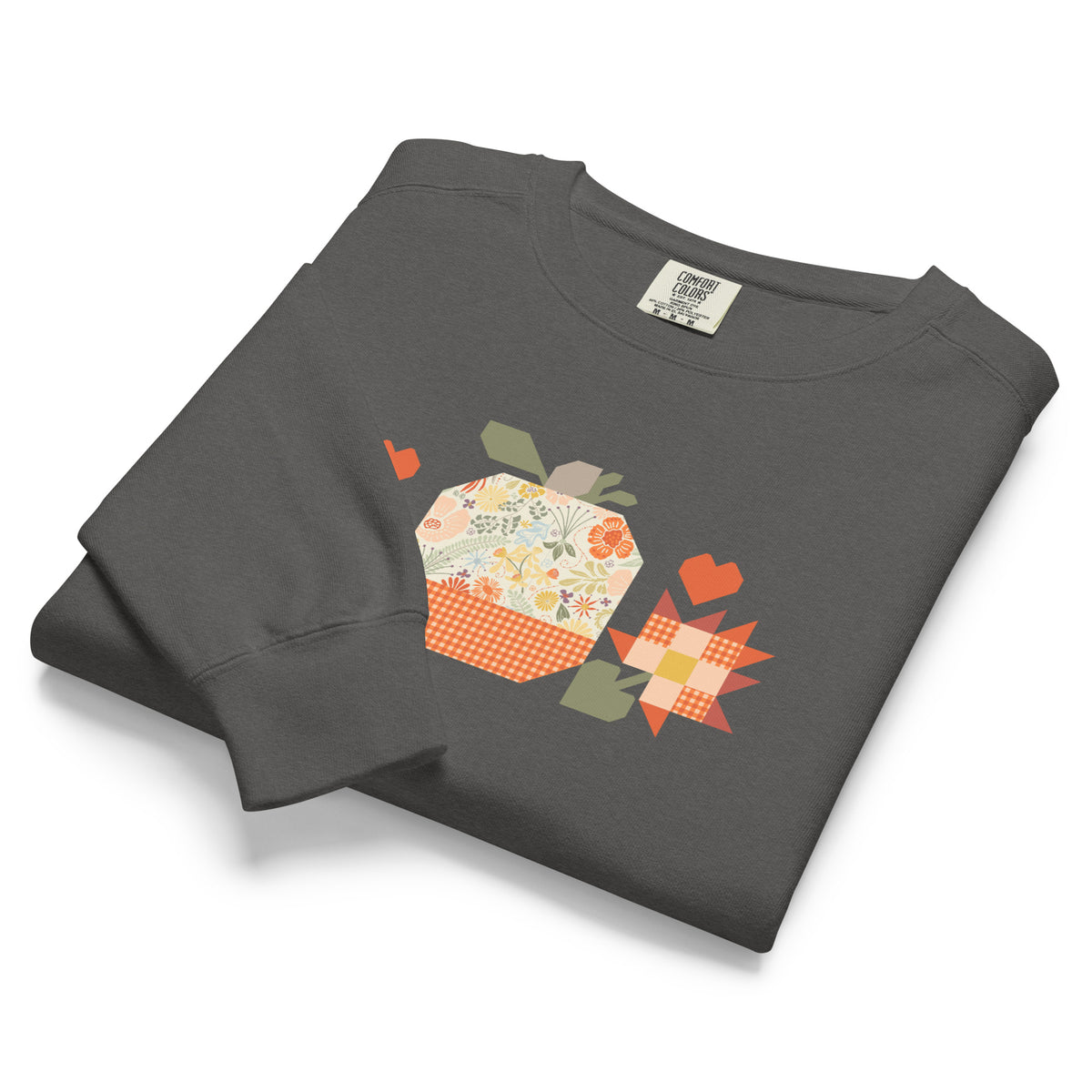 Falling for Fall patchwork pumpkin with quilt-block stars and hearts on a garment-dyed crewneck sweatshirt in pepper grey, folded, angled view – Kate Spain design for Pat Sloan