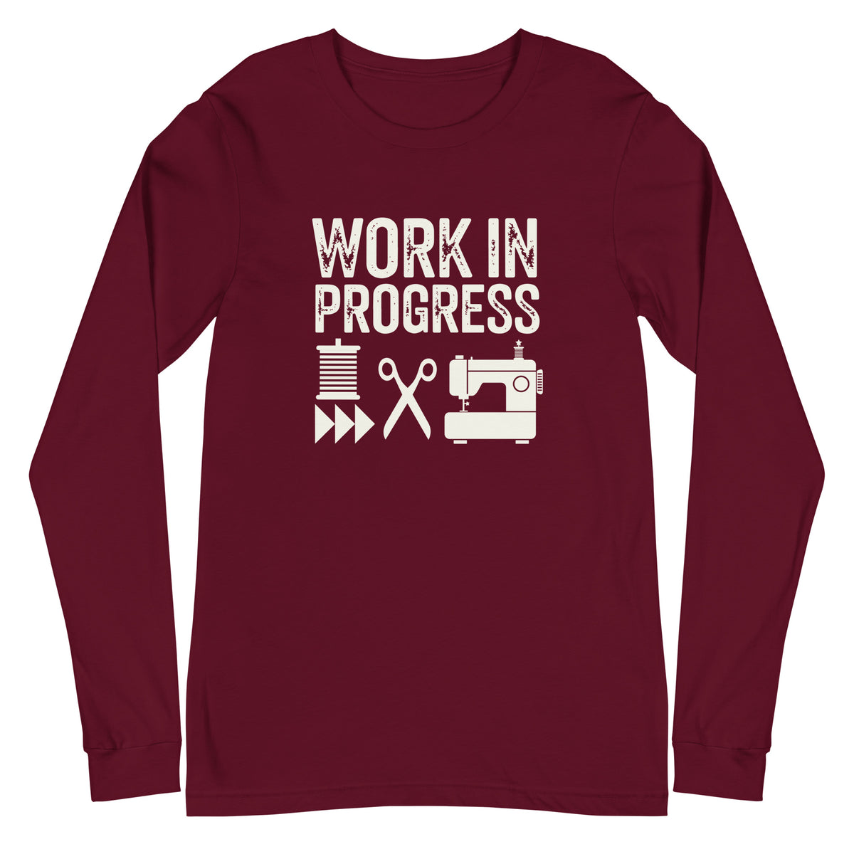 Work in Progress lettering with spool, scissors and sewing machine icons on a unisex long-sleeve tee in maroon, front view – Kate Spain design for Pat Sloan