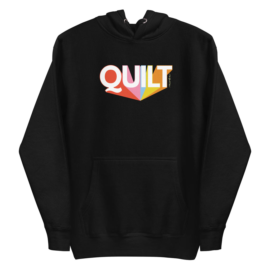 Moda QUILT logo with orange, pink, blue and yellow rays on a premium hoodie in black, front view – Kate Spain design