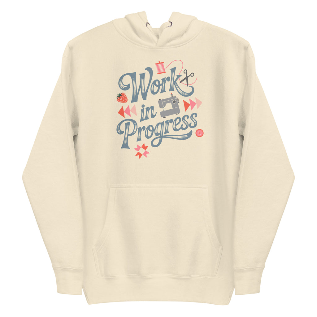 Work in Progress sewing design with flying geese, sewing machine, strawberry and thread spool on a pullover hoodie in vintage white, front view – Kate Spain design for Pat Sloan