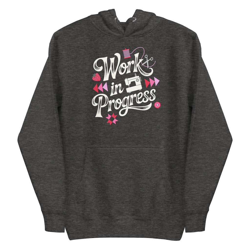 Work in Progress sewing design with flying geese, sewing machine, strawberry and thread spool on a pullover hoodie in charcoal grey, front view – Kate Spain design for Pat Sloan