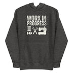 Work in Progress Mod distressed lettering with thread, scissors and sewing machine on a pullover hoodie in charcoal grey, front view – Kate Spain design for Pat Sloan