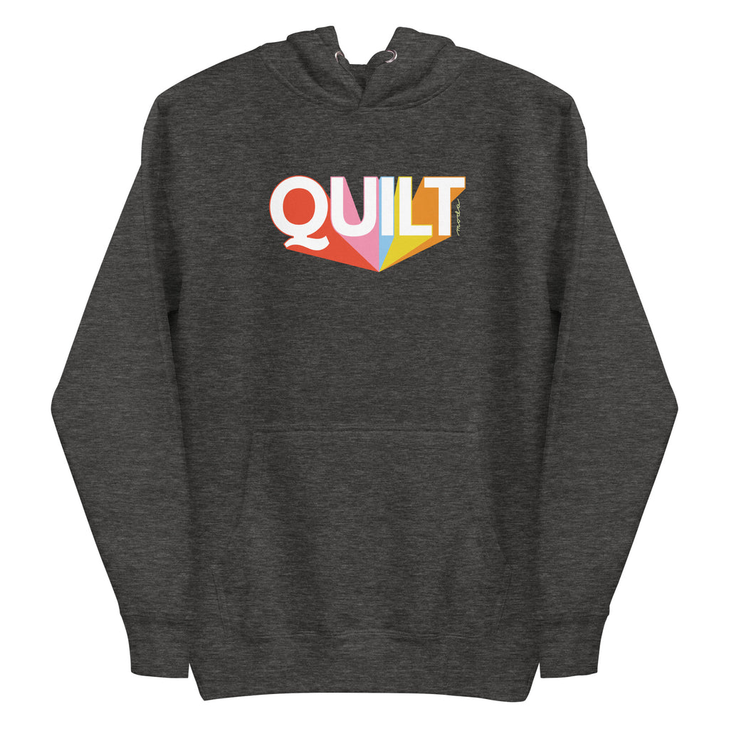 Moda QUILT logo with orange, pink, blue and yellow rays on a premium hoodie in charcoal grey, front view – Kate Spain design