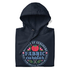 Fabric Curator Society of Stashers badge with a tomato pincushion on a pullover hoodie in navy, folded close-up of the design – Kate Spain design for Pat Sloan