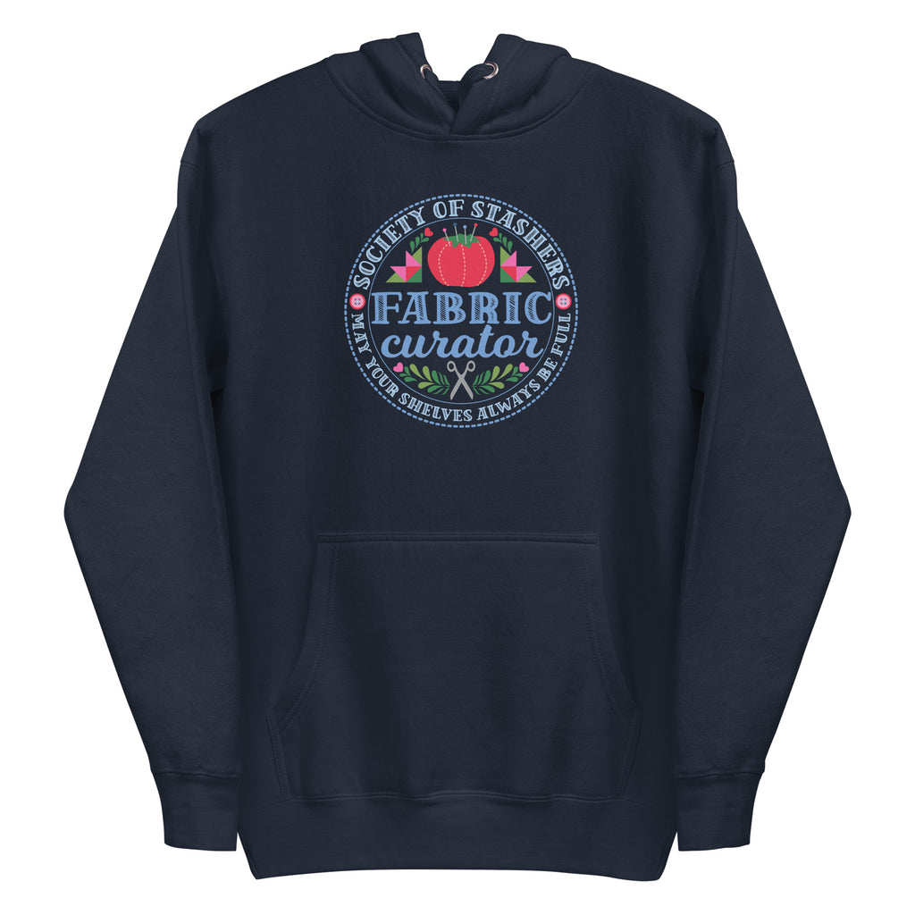 Fabric Curator Society of Stashers badge with a tomato pincushion on a pullover hoodie in navy, front view – Kate Spain design for Pat Sloan