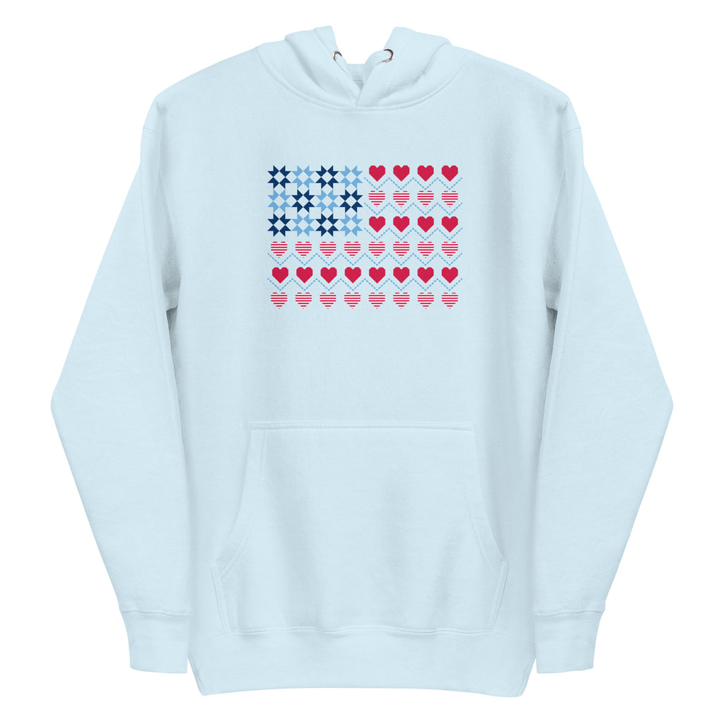 United We Quilt patchwork flag with quilt-block stars and heart stripes on a pullover hoodie in sky blue, front view – Kate Spain design for Pat Sloan