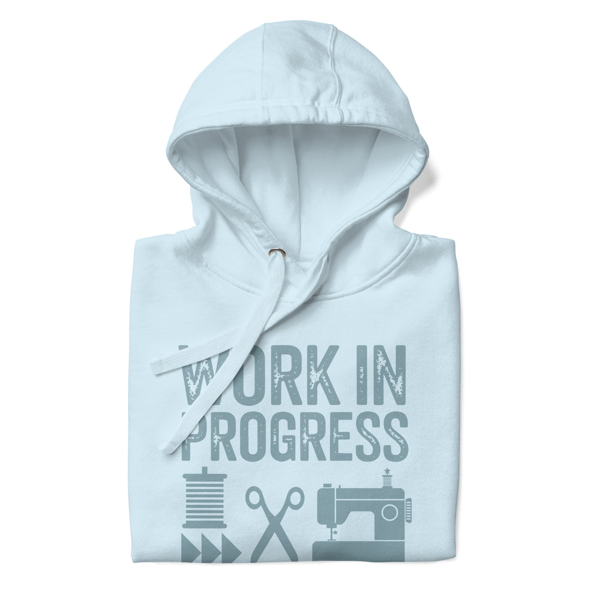 Work in Progress Mod distressed lettering with thread, scissors and sewing machine on a pullover hoodie in sky blue, folded close-up of the design – Kate Spain design for Pat Sloan