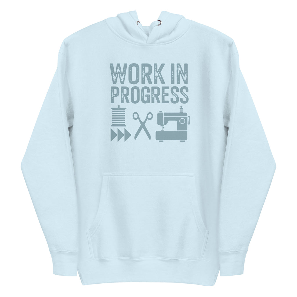 Work in Progress Mod distressed lettering with thread, scissors and sewing machine on a pullover hoodie in sky blue, front view – Kate Spain design for Pat Sloan