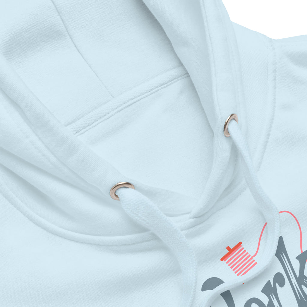 Work in Progress sewing design with flying geese, sewing machine, strawberry and thread spool on a pullover hoodie in sky blue, close-up of the hood and print – Kate Spain design for Pat Sloan