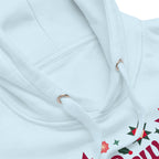 Sew Merry + Bright lettering with quilt-block stars, holly and a thread spool on a pullover hoodie in sky blue, close-up of the hood and print – Kate Spain design for Pat Sloan