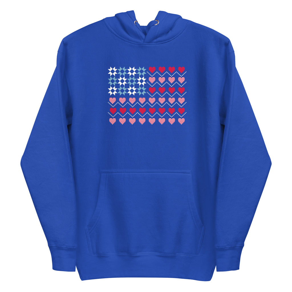 United We Quilt patchwork flag with quilt-block stars and heart stripes on a pullover hoodie in royal blue, front view – Kate Spain design for Pat Sloan