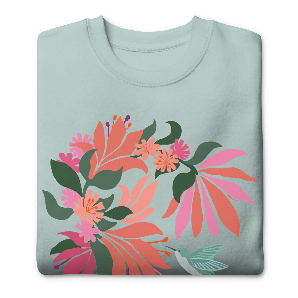 Hummingbird among coral tropical flowers on a crewneck sweatshirt in agave, folded close-up of the design – Kate Spain design