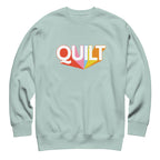 Moda QUILT logo with orange, pink, blue and yellow rays on a premium sweatshirt in agave, front view – Kate Spain design