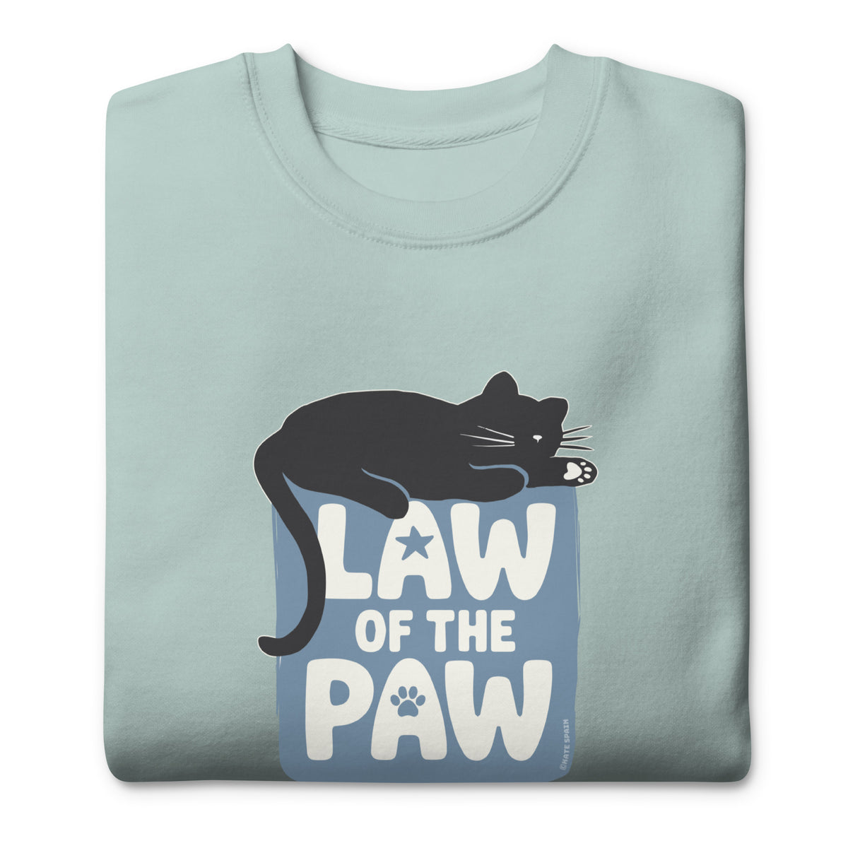 Law of the Paw® design with a cat napping on the logo on a crewneck sweatshirt in agave, folded close-up of the design – Kate Spain design