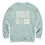 Work in Progress lettering with sewing icons on a premium sweatshirt in agave, front view – Kate Spain design for Pat Sloan