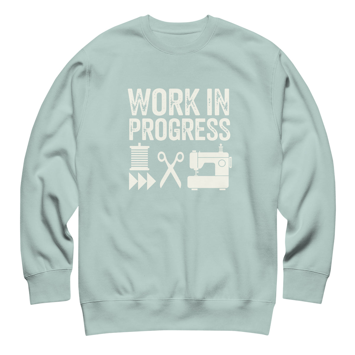 Work in Progress lettering with sewing icons on a premium sweatshirt in agave, front view – Kate Spain design for Pat Sloan