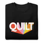 Moda QUILT logo with orange, pink, blue and yellow rays on a premium sweatshirt in black, folded close-up of the design – Kate Spain design